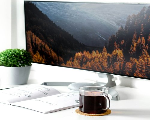 Glass of water and a cup of coffee on a desk